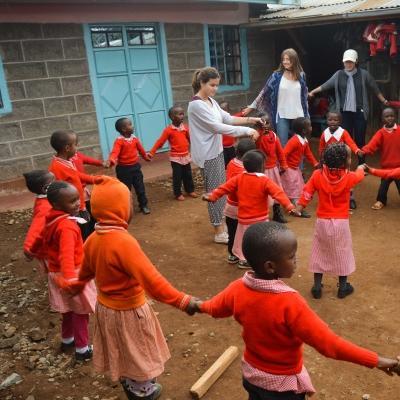 Volunteers play a game with the children outside during their volunteer work with children for teenagers in Kenya Projects Abroad volunteers assist with childcare volunteering for teenagers in Kenya as they play educational games with the children in the school yard